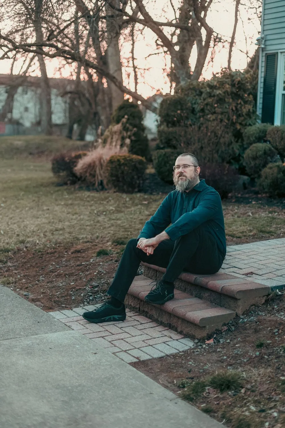 Aaron Silverman sitting on brick front steps at dusk